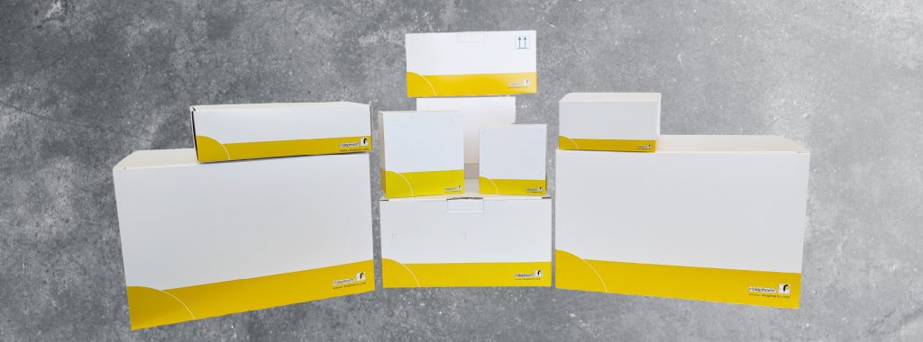 A collection of white and yellow boxes arranged on a grey surface.