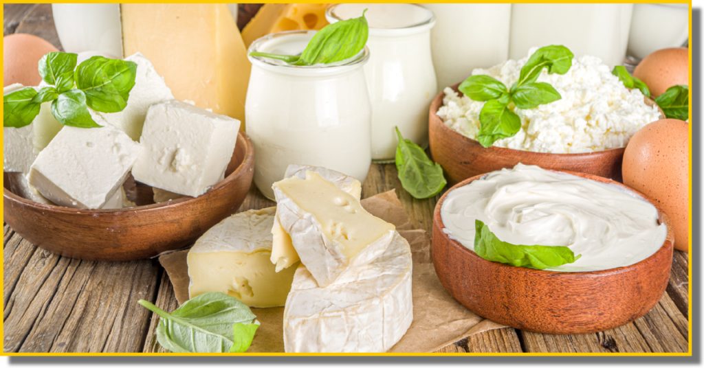 A variety of dairy products and eggs arranged on a rustic wooden table.