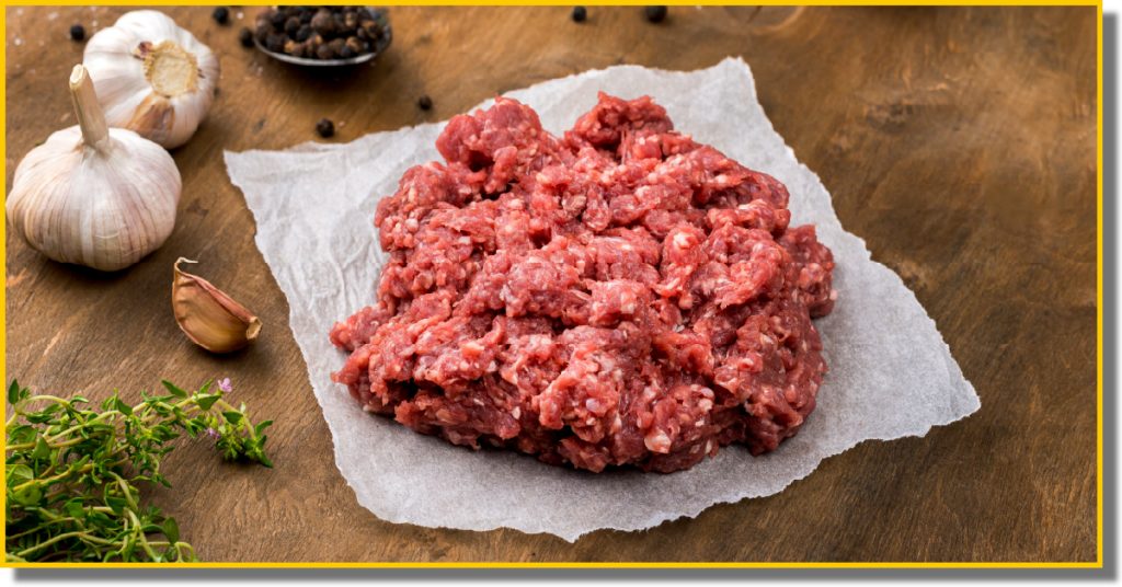 Raw ground beef placed on a wooden cutting board
