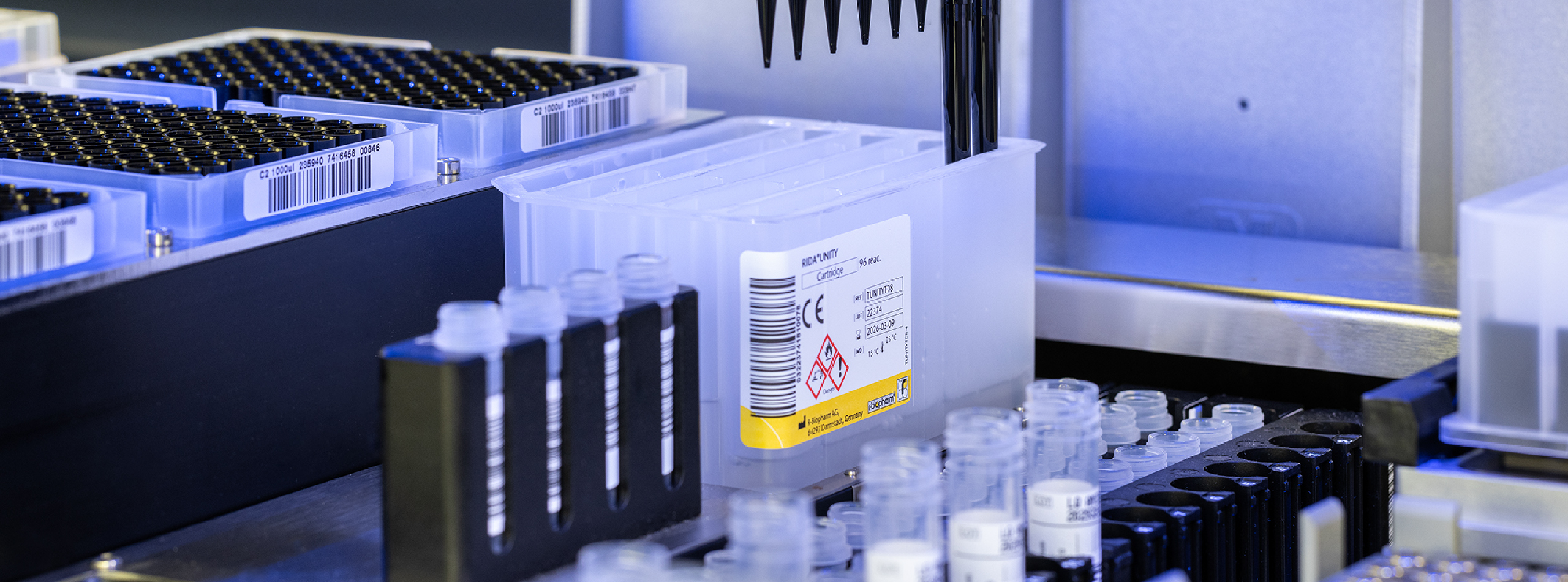 A laboratory machine displaying a tray filled with test tubes and various scientific equipment.