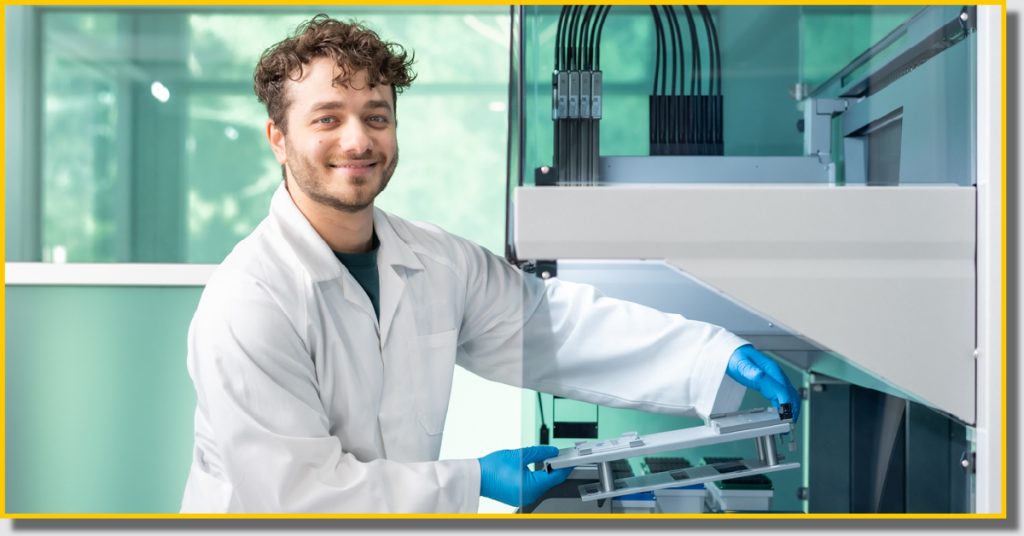 A man wearing a lab coat is holding a piece of equipment in an R-Biopharm laboratory.