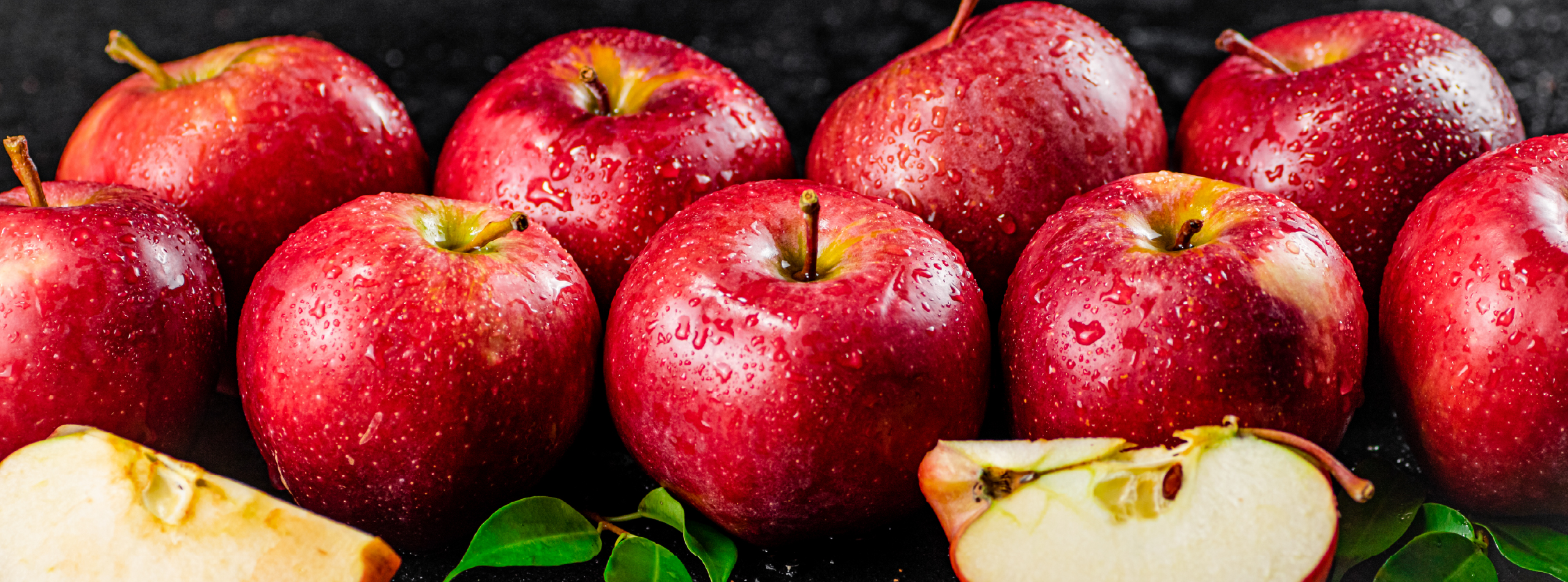 A cluster of red apples with one apple sliced to reveal its interior
