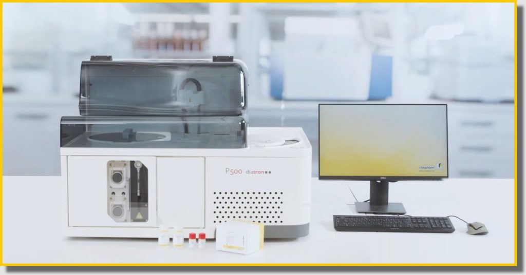 A computer and a laboratory machine are placed on a desk, showcasing a workspace for scientific research and analysis.