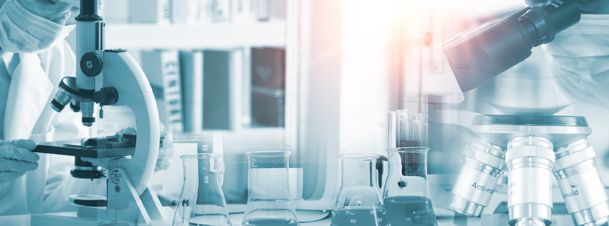 A scientist in a lab coat examining a microscope in a laboratory setting.