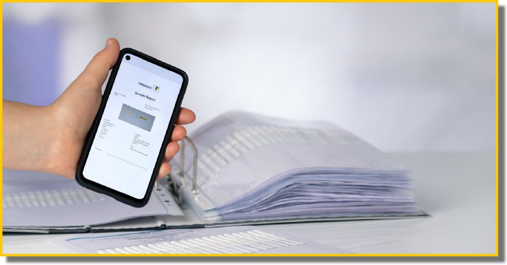 a hand holding a phone above a folder containing documents
