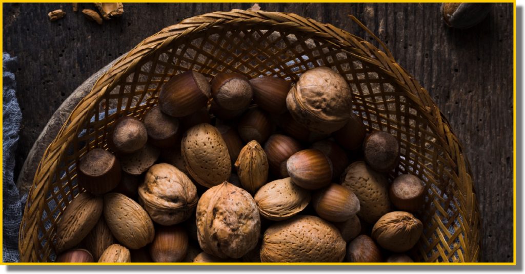 A basket filled with assorted nuts placed on a rustic wooden table.