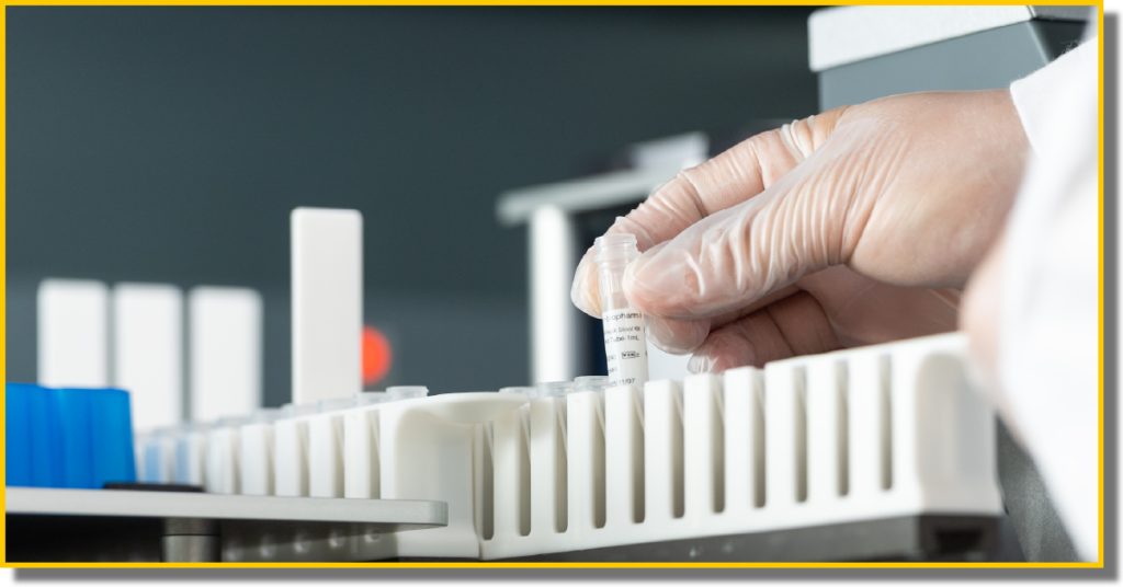 a man in a white lab coat places a tube into a container in preparation for processing